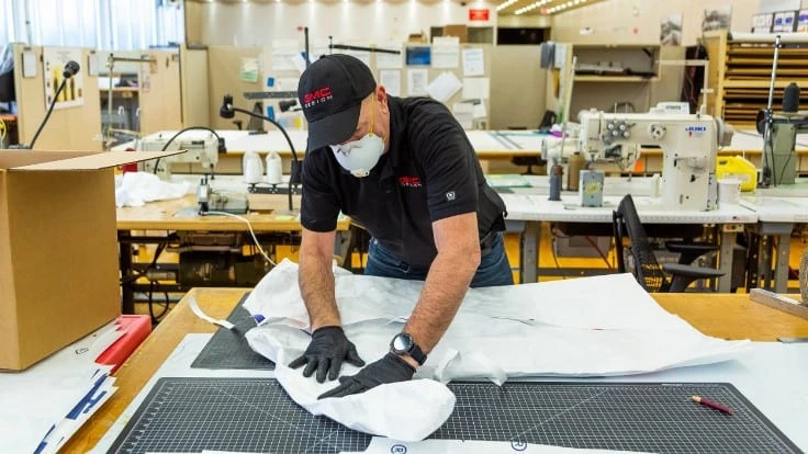 GM workers at the company's technical center in Warren, Michigan, make gowns for doctors and nurses. Safety lessons from medical production are informing how the company will keep workers safe when it calls them back to factories.