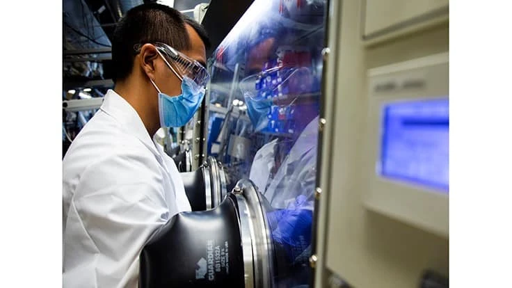 Michael Wang, materials science and engineering Ph.D. candidate, uses a glove box to inspect a lithium metal battery cell in a lab at the University of Michigan in 2020.