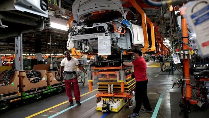 General Motors assembly workers connect a battery pack underneath a partially assembled 2018 Chevrolet Bolt EV vehicle on the assembly line at Orion Assembly in Lake Orion, Michigan, U.S., March 19, 2018.