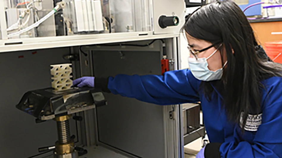 Johns Hopkins graduate student Beijun Shen places liquid crystal elastomer structure in drop tester machine.