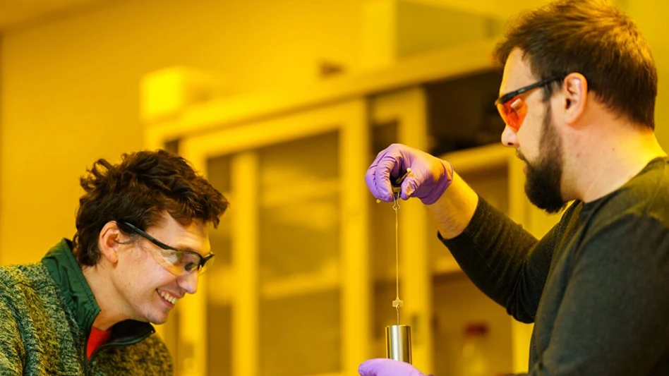 Samuel Leguizamon, left, watches as Alex Commisso stretches 3D material that they printed at Sandia National Laboratories, using Selective Dual-Wavelength Olefin Metathesis 3D-Printing, or SWOMP.