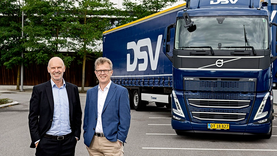 Executives from DSV and Volvo Trucks stand in front of an electric truck.