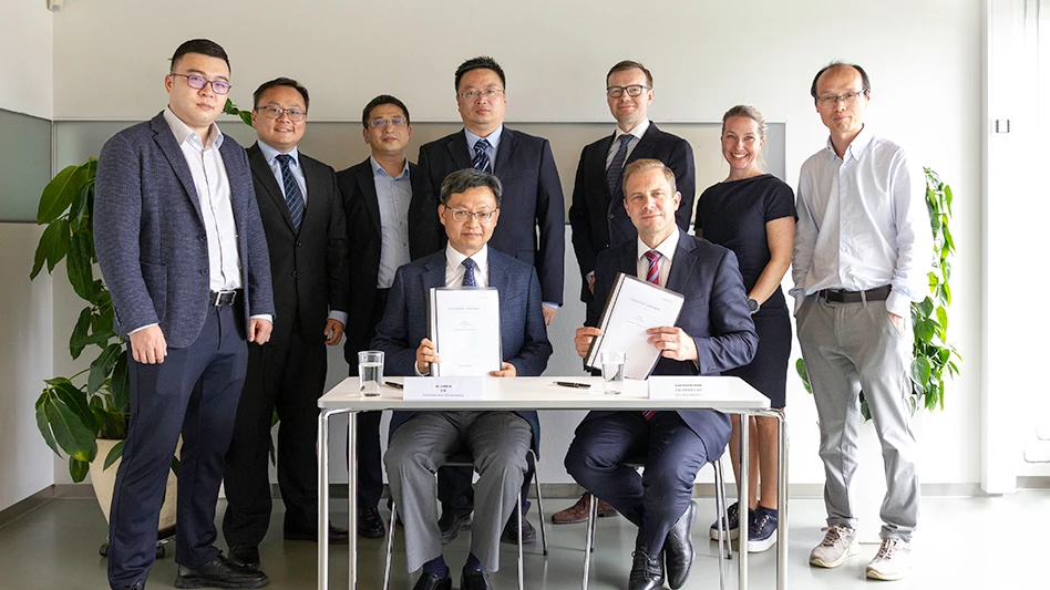 A group of people poses around a table.