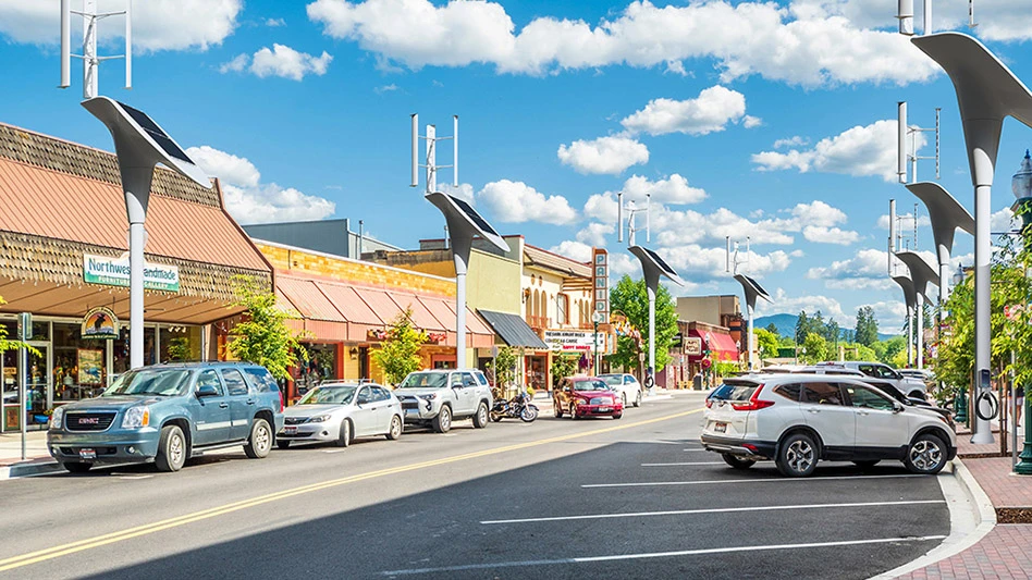 Several cars parked along a street lined with electric vehicle chargers.