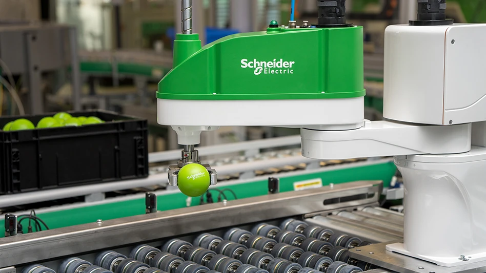 A robot grasps a small sphere next to an assembly line