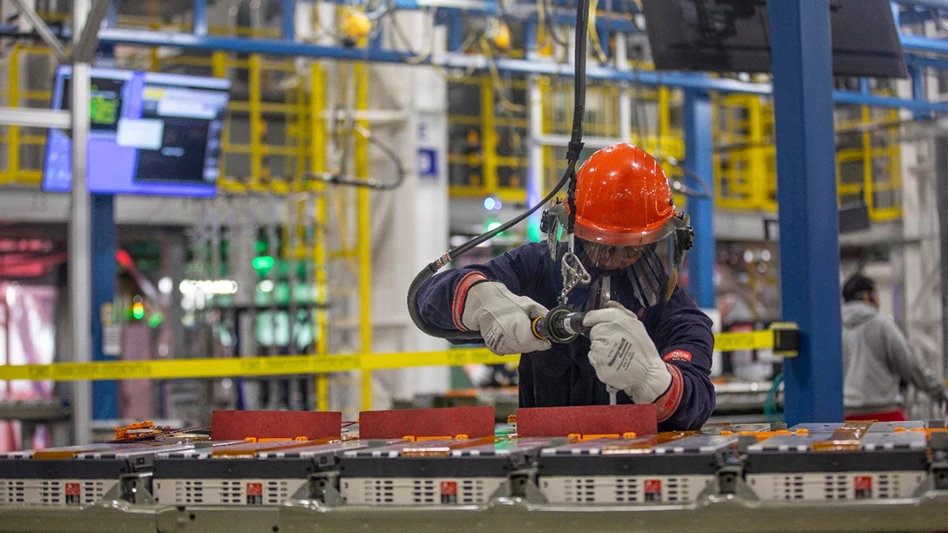 A worker assembles a component inside a factory
