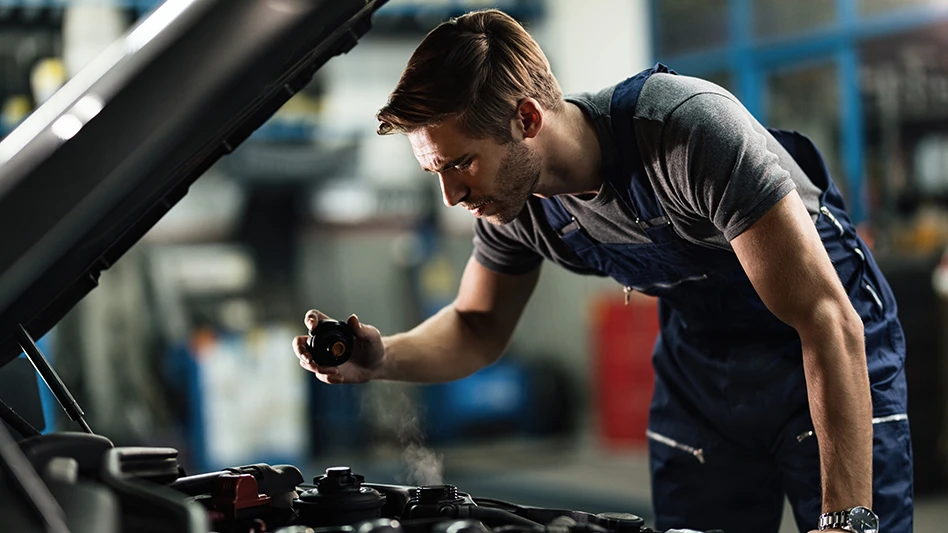 A mechanic works on the engine of a vehicle