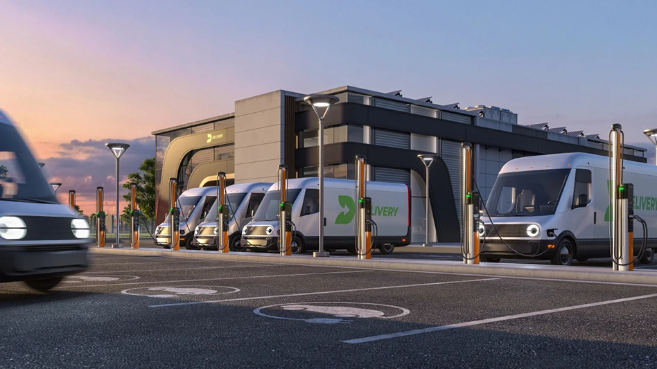 Several vans charge in a parking lot with a building in the background