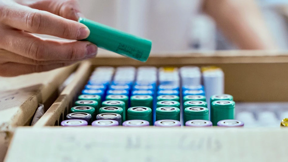 A hand takes a battery from a box