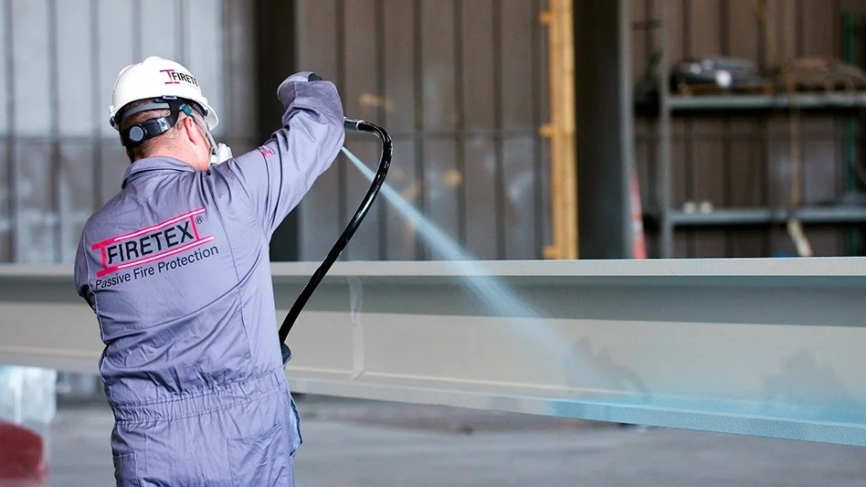 A person sprays a hose at a factory