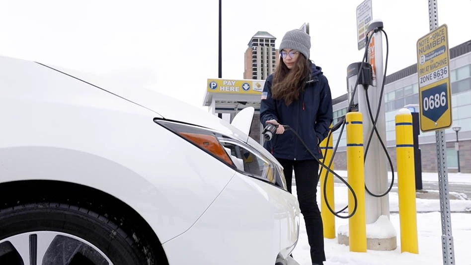 A person charges an electric vehicle