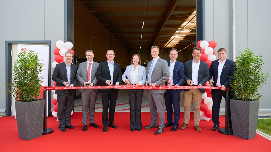 People standing on a red carpet cutting a ribbon