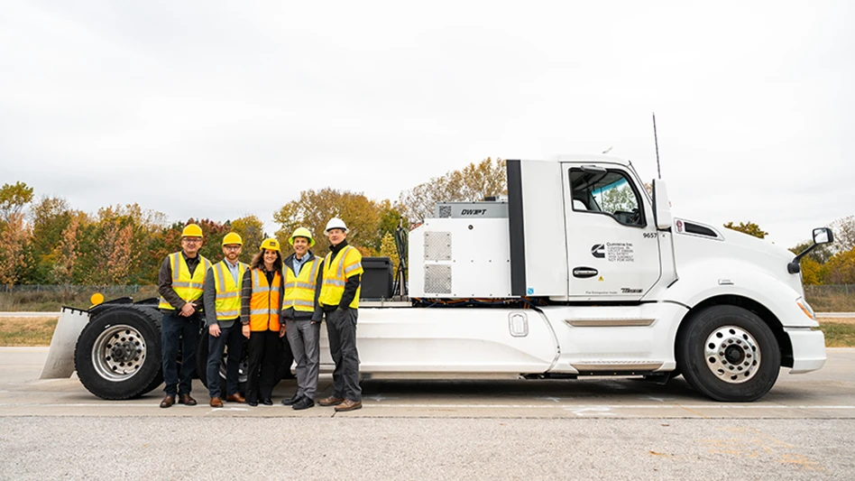 Five people standing in front of a truck